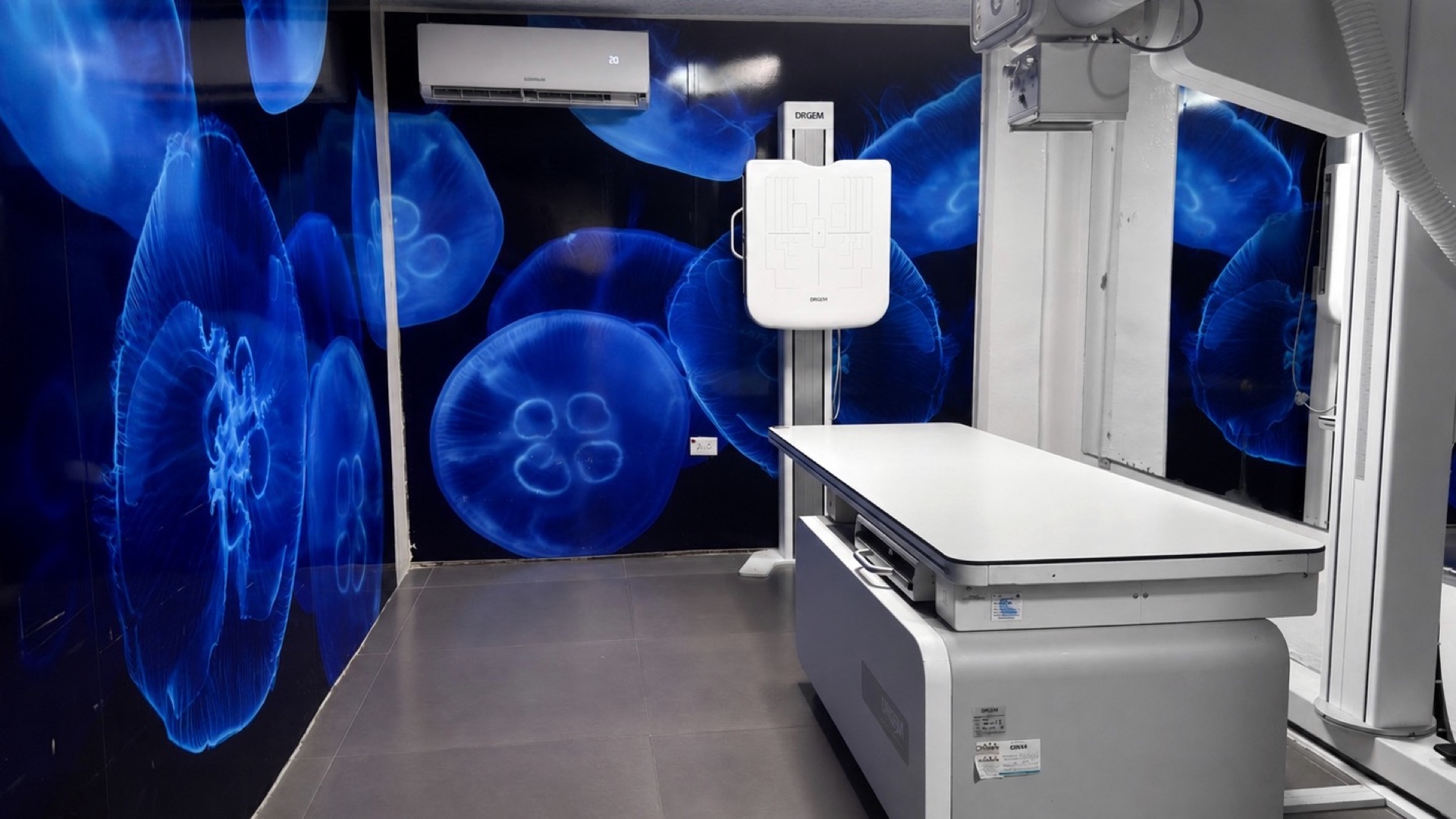 La sala de rayos X, con la mesa de radiografía digital y la columna del tubo.