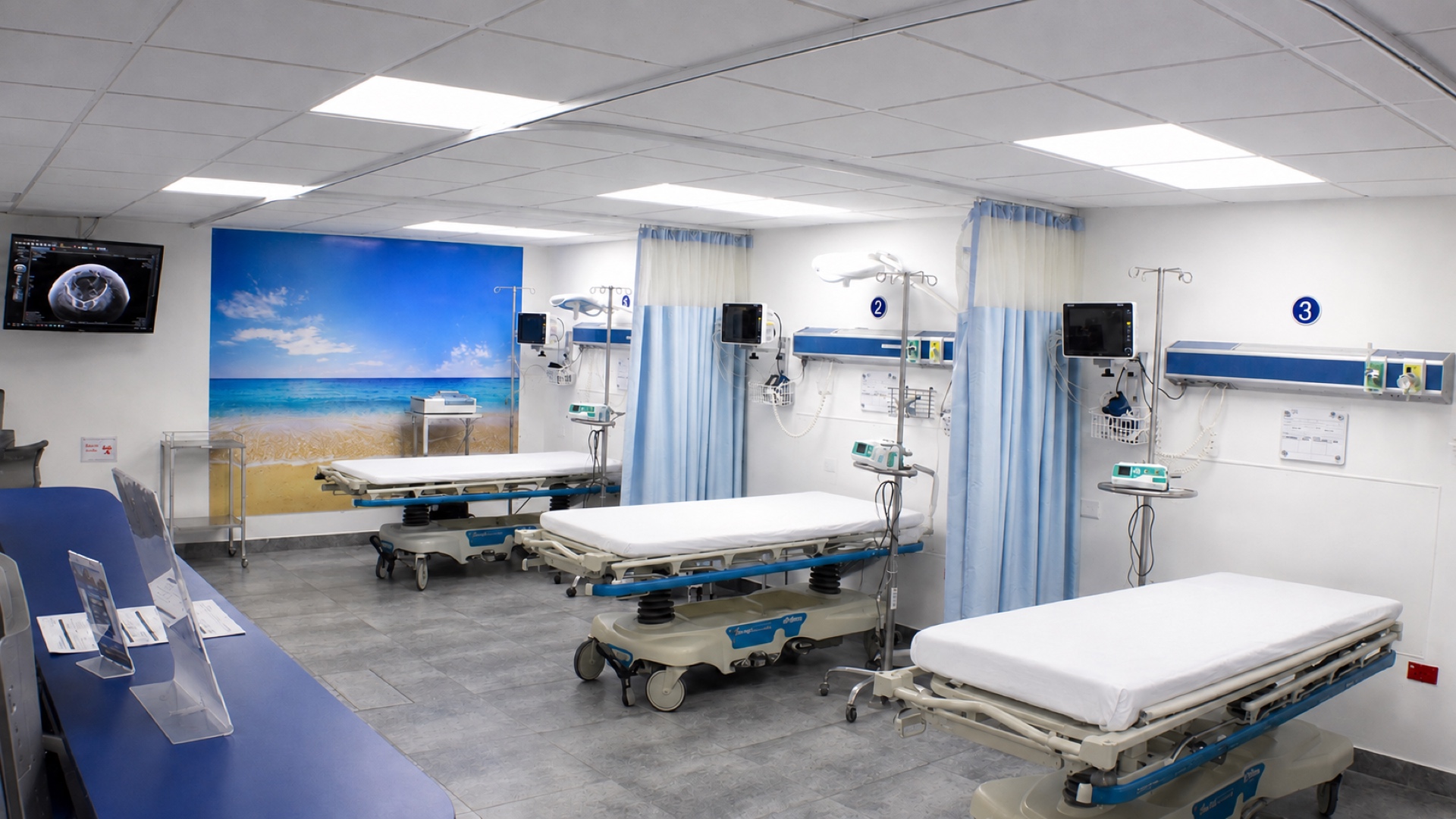 Cubículos de urgencias del Hospital Internacional, con camillas, monitor y ecógrafo.