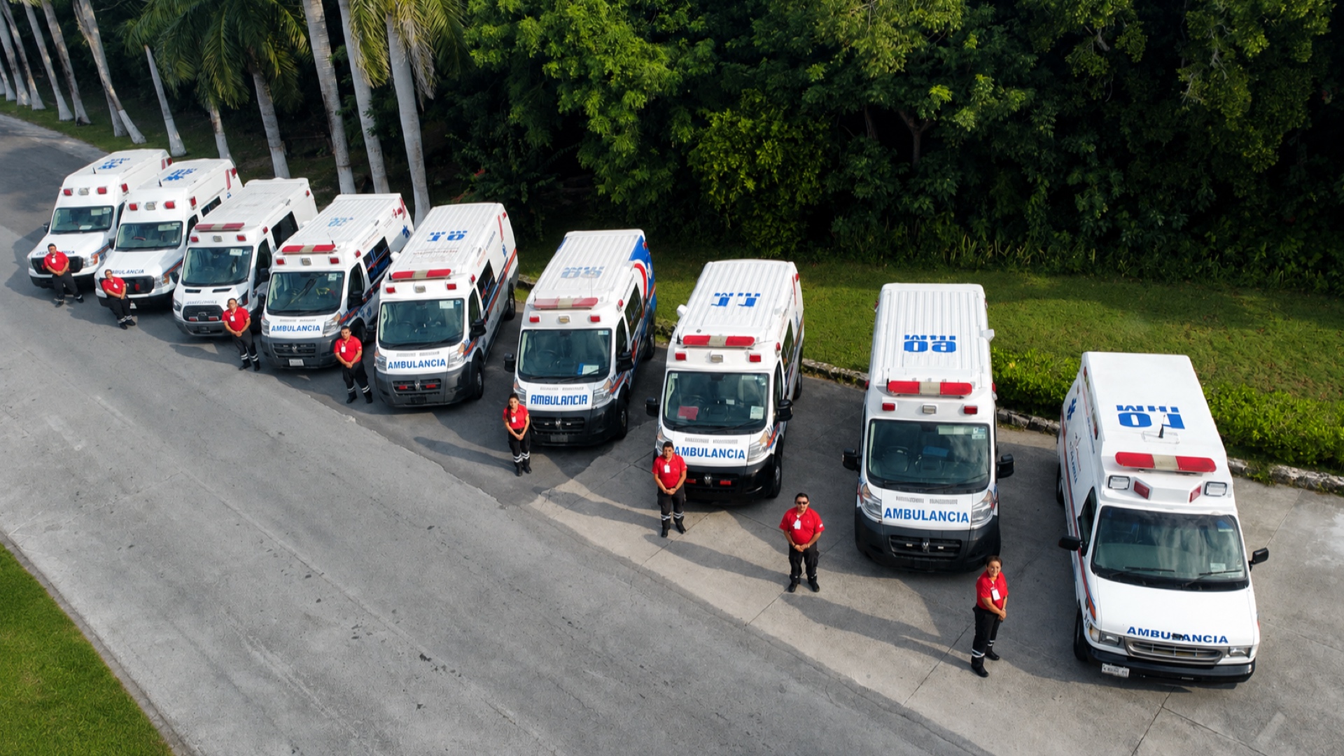 La flota de ambulancias del Hospital Internacional formada, con un paramédico junto a cada unidad.